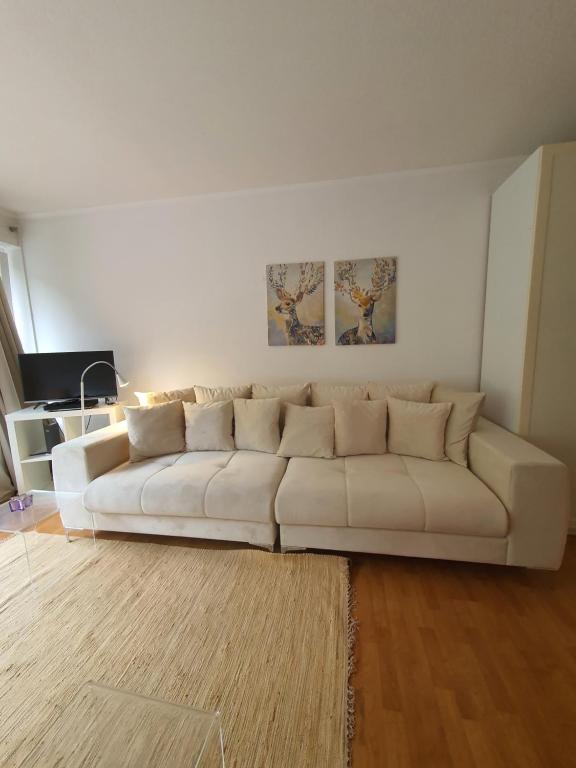 ein weißes Sofa im Wohnzimmer in der Unterkunft Apartment mit Blick auf das Eversten Holz 42qm in Oldenburg
