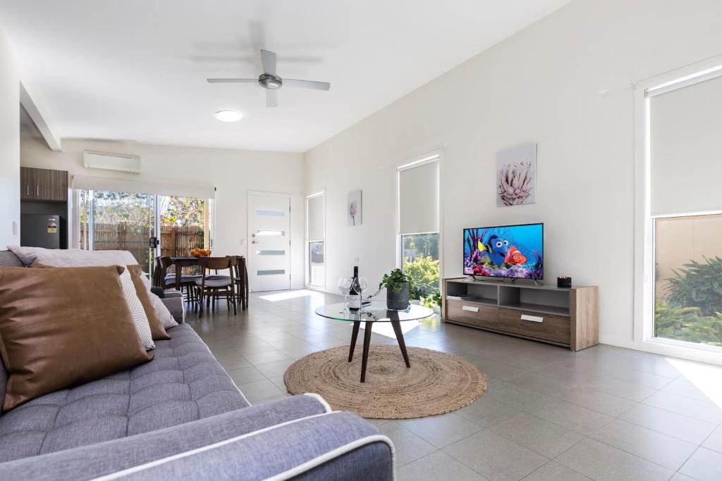 a living room with a couch and a tv at 2 Bedroom w/Parking Near Central Cessnock in Cessnock