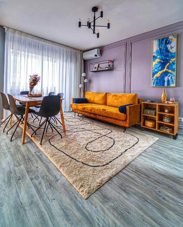 a living room with a yellow couch and a table at Delux Suite - Apartament 100 de m2 cu 3 camere și parcare gratuită, lângă Arena Mall in Centrul Bacău in Bacău