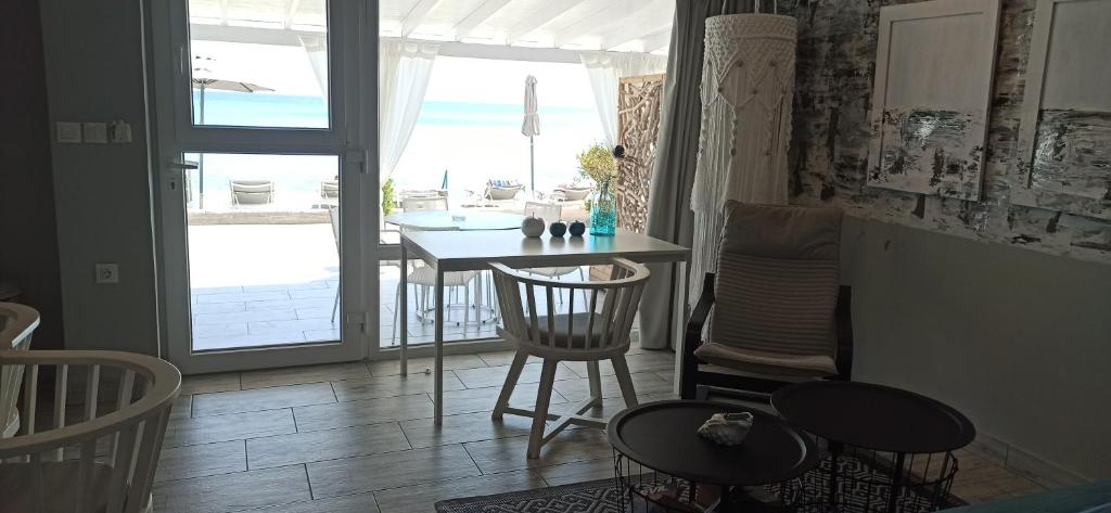 a room with a table and chairs and a view of the ocean at Pillbox Seafront Studios and Apartments in Kardamaina