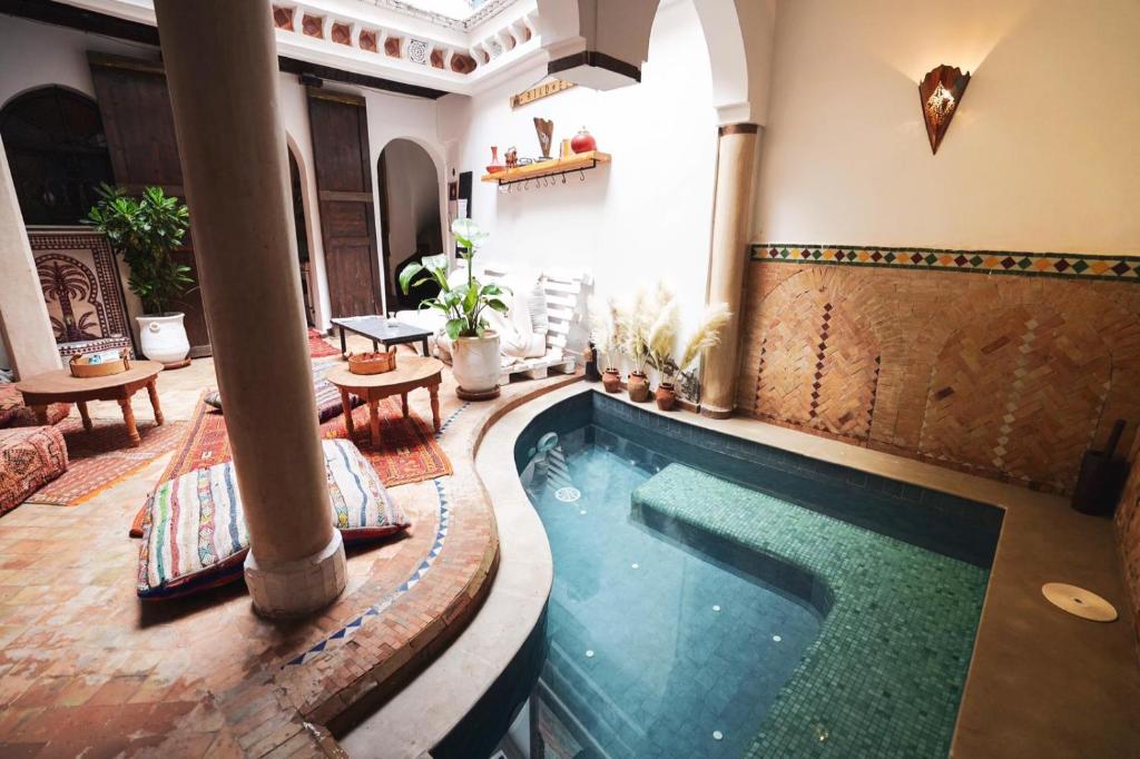 a swimming pool in the middle of a house at Riad Elli Marrakech in Marrakesh