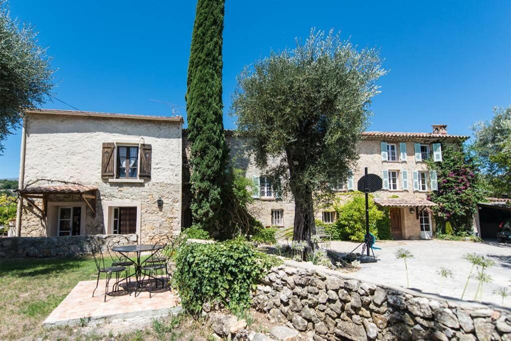 Casa de piedra con mesa y pared de piedra en Studio indépendant dans mas provencal, en Le Rouret