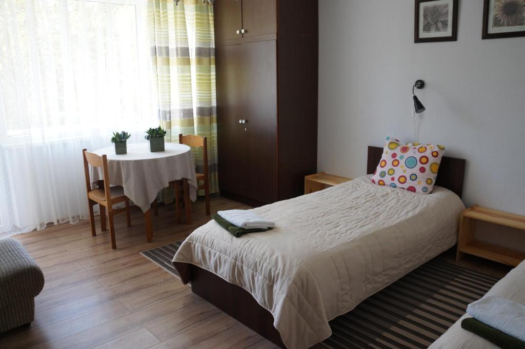sypialnia z łóżkiem i stołem z krzesłem w obiekcie Mildos butas w mieście Birsztany