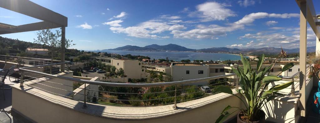 - un balcon avec vue sur la ville et l'eau dans l'établissement VUE MAGNIFIQUE SUR BAIE AJACCIO, à Porticcio