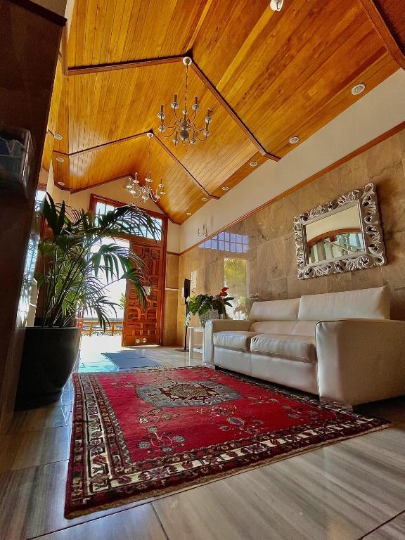 a living room with a couch and a red rug at Apartamentos Tapahuga in Playa de Santiago