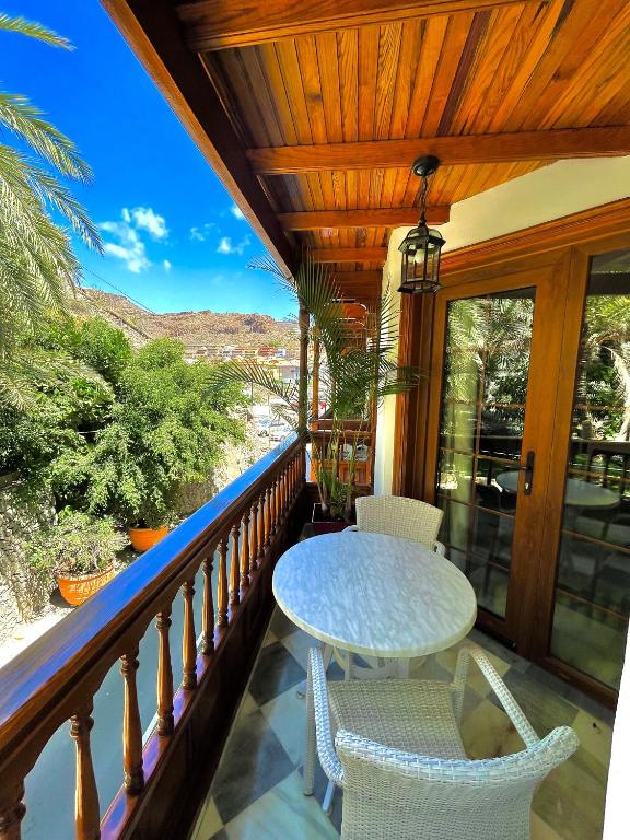 a porch with a table and chairs on a balcony at Apartamentos Tapahuga in Playa de Santiago