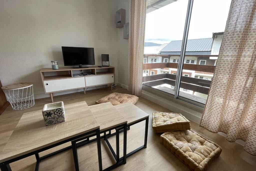 a living room with a tv and a large window at T2 pla d'adet au pied des pistes in Saint-Lary-Soulan