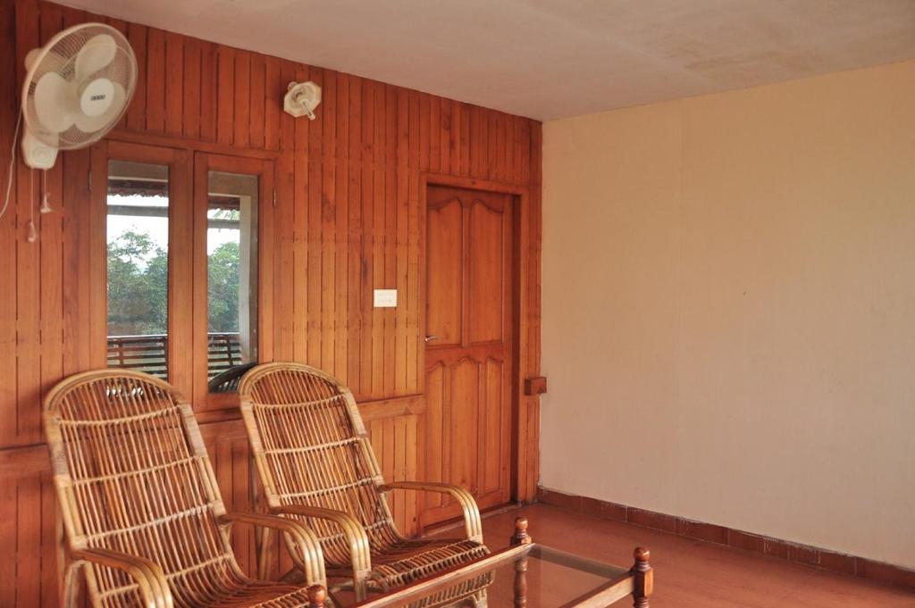 2 sillas de mimbre sentadas en una habitación con ventana en Backwater Breeze, en Kumarakom
