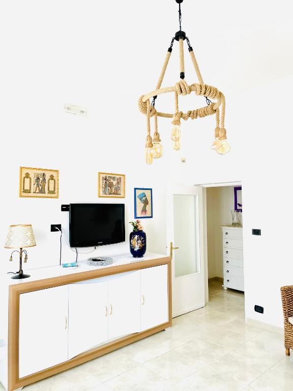 a living room with a tv and a chandelier at Relax House in Bari