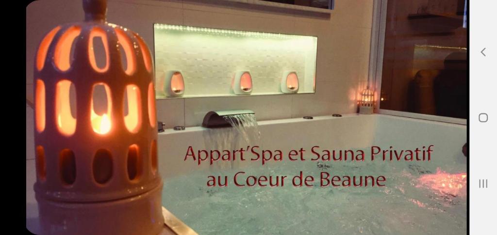 a bathroom with a bath tub with a sign on it at Appart' Spa et Sauna Privatif Au Cœur De Beaune in Beaune