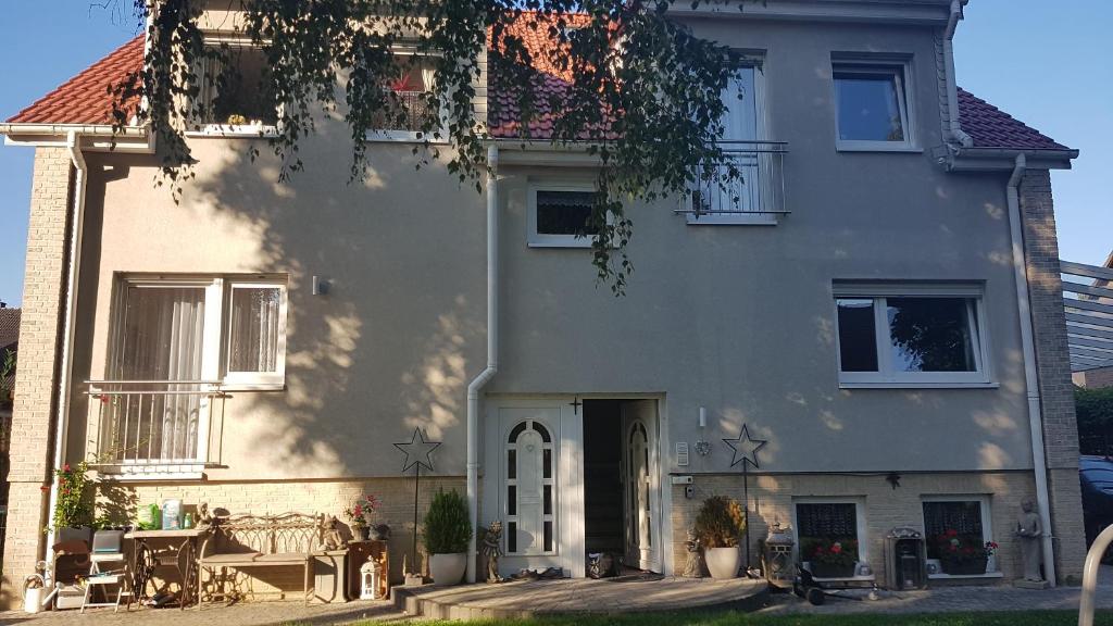 una gran casa blanca con un árbol delante en 2 Zimmerwohnung am Flughafen Schönefeld, en Berlín