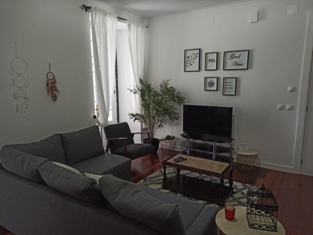 - un salon avec un canapé et une télévision dans l'établissement Alojamento Fernandes, à Horta
