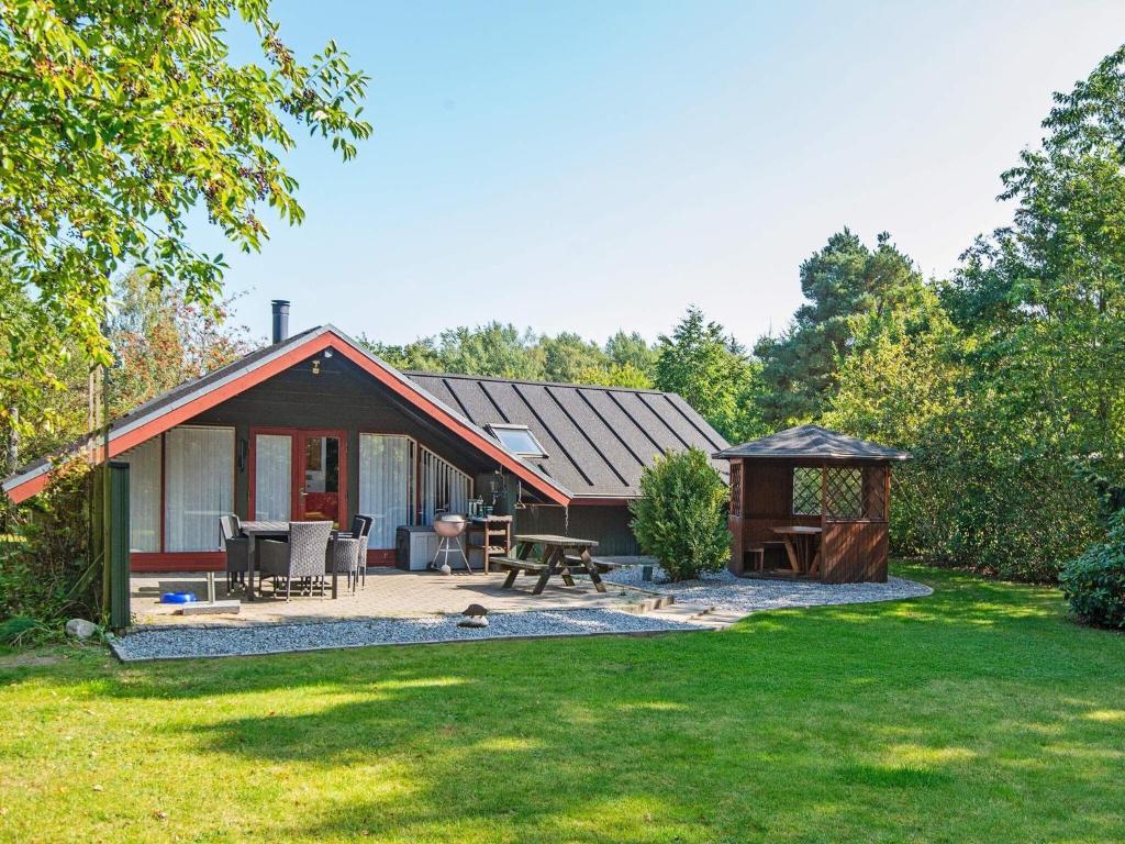 una piccola casa con tavolo da picnic e gazebo di Holiday home Fårvang X a Fårvang