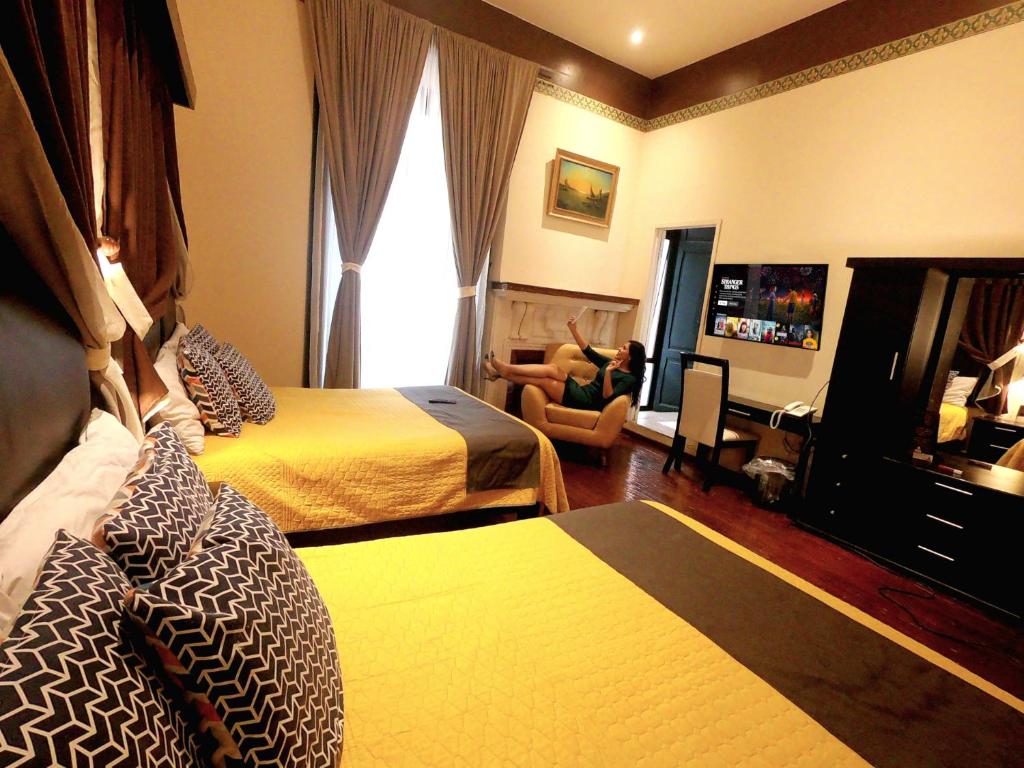 um quarto de hotel com duas camas e uma janela em Hotel Providencia em Zacatecas
