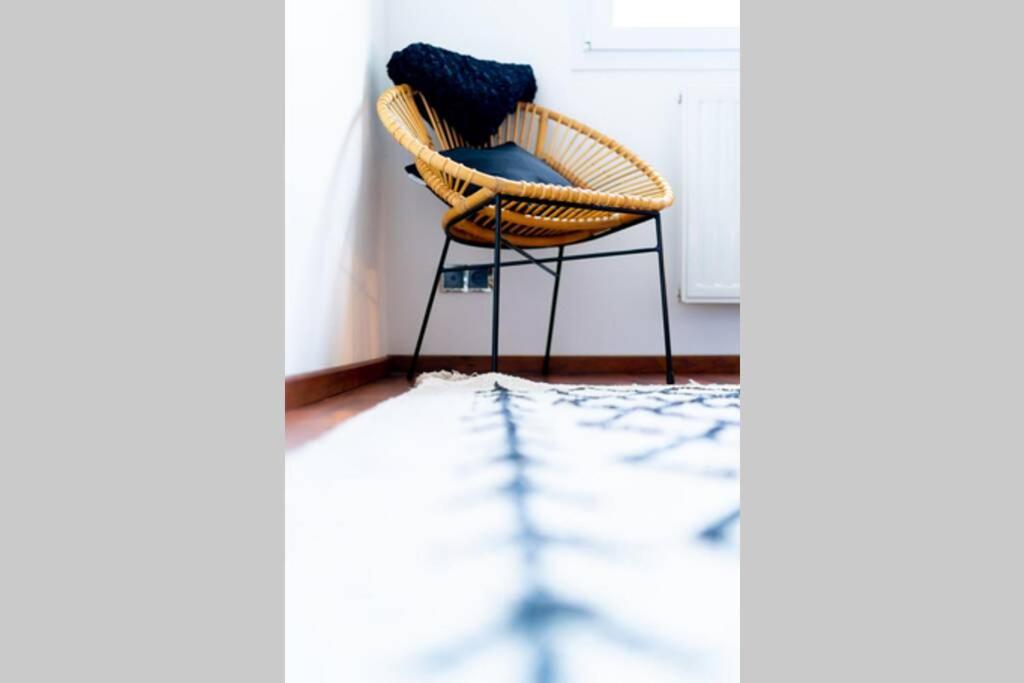 a wicker chair with a blue pillow in a room at La Villetta G Blotzheim - Appartement de Standing in Blotzheim