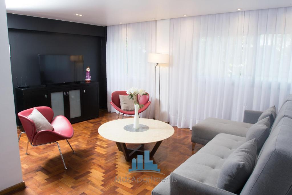 uma sala de estar com um sofá, cadeiras e uma mesa em Mdz Apartments II em Mendoza