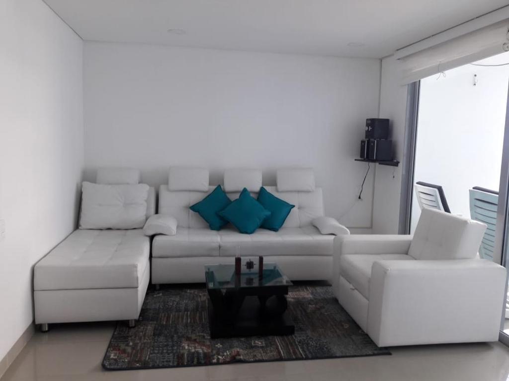 a living room with a white couch and blue pillows at Seway Morros Cartagena in Cartagena de Indias