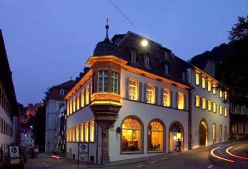 a lit up building on a city street at night at Arthotel Heidelberg in Heidelberg