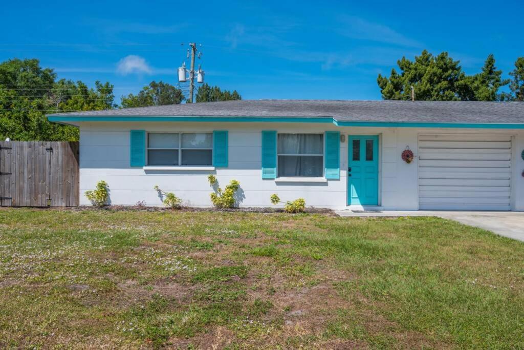 una casa blanca con una puerta azul y un patio en 3606 Villa Franca - Pet Friendly, en Sarasota