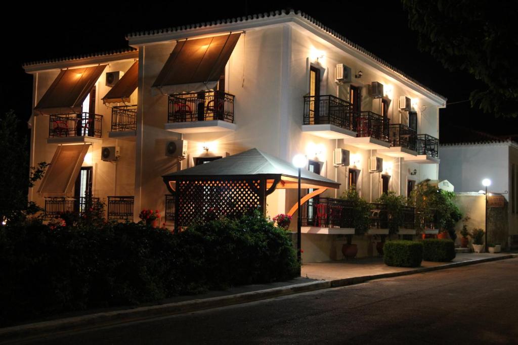 a large white building with balconies at night at Hotel Aris in Methoni