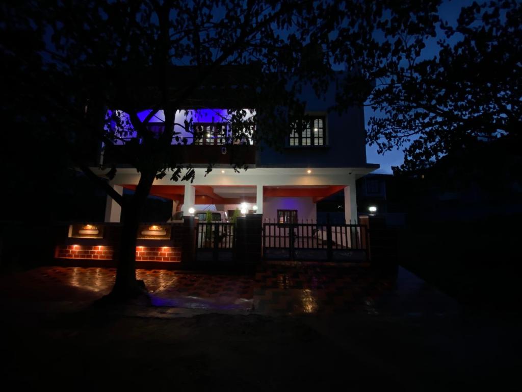 uma casa à noite com uma árvore em primeiro plano em Coorg Residency home stay em Kushalanagar