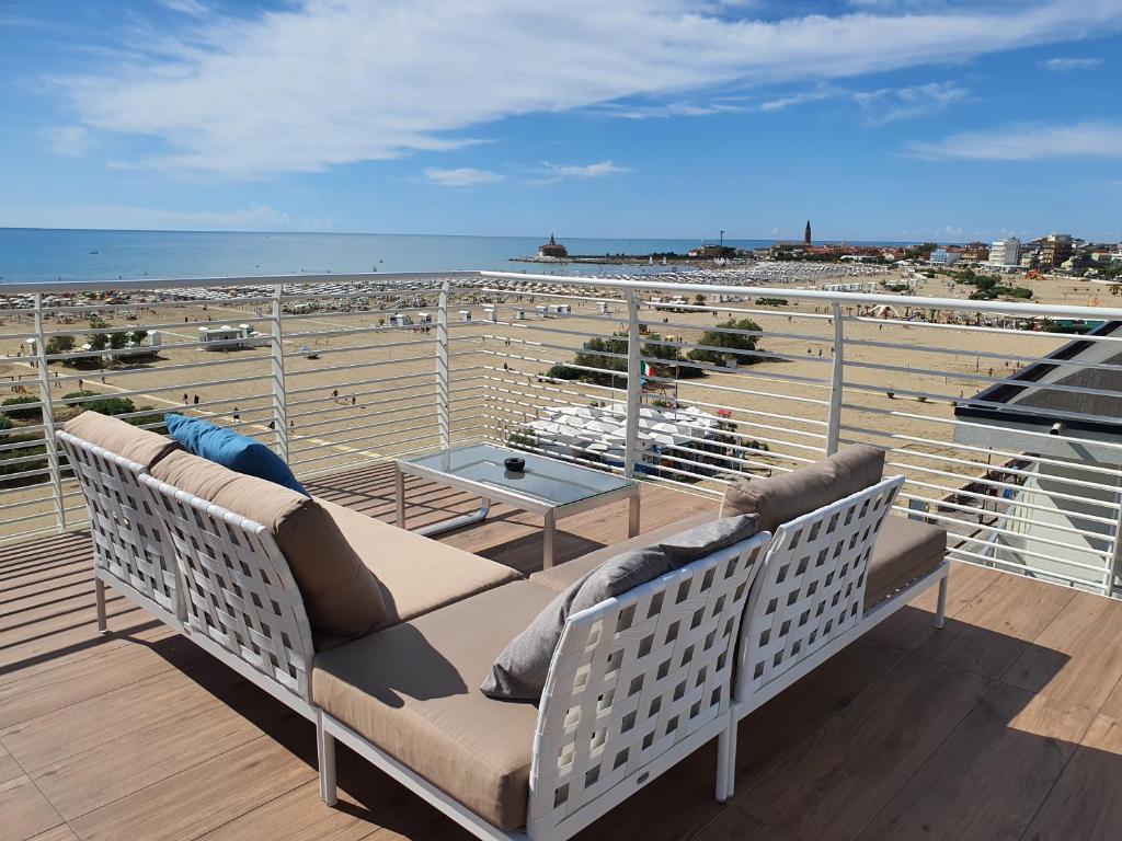 un balcón con 2 sillas, una mesa y el océano en Hotel Doriana, en Caorle
