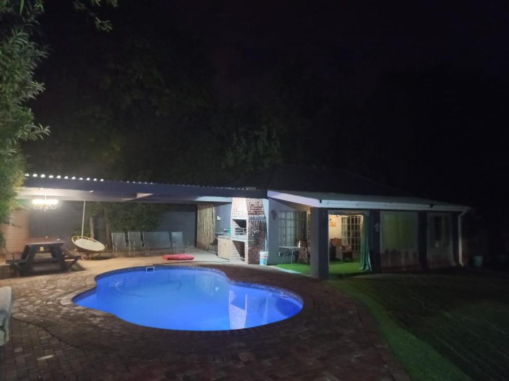 a swimming pool in a yard at night at Relax in Joy & Mignon for a bushveld Feeling in Bloemfontein