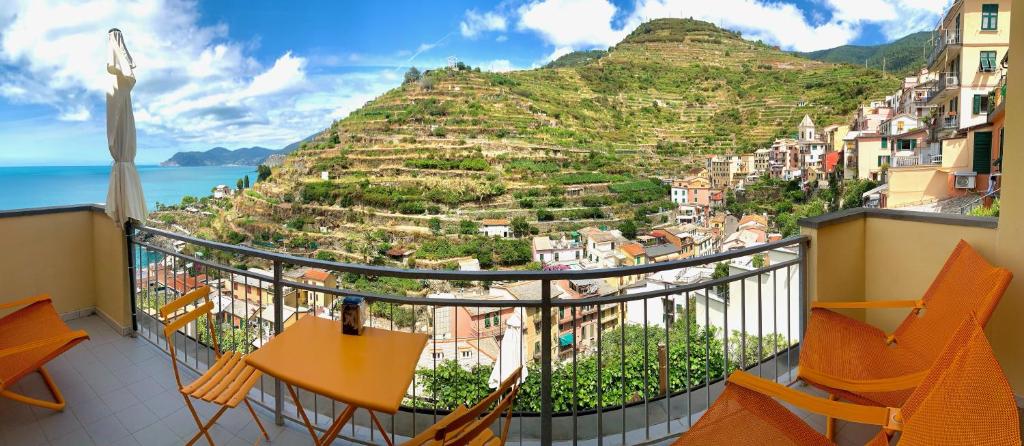 a balcony with chairs and a view of a mountain at Orizzonti Apartments in Manarola