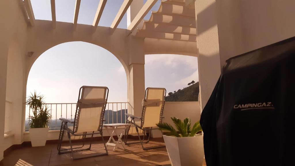 um grupo de cadeiras numa varanda com vista para o oceano em apartamento Xeresa del monte Resort em Jeresa