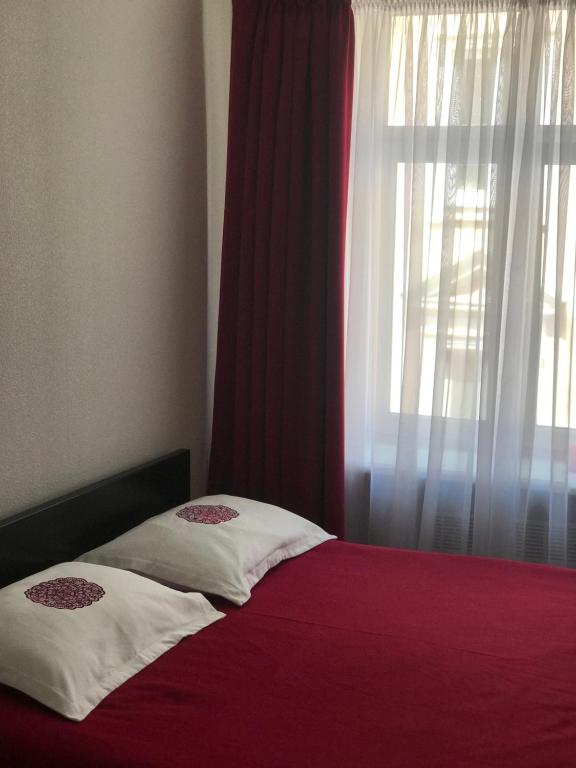 a bed with a red blanket and a window at MaryLu home in Lviv