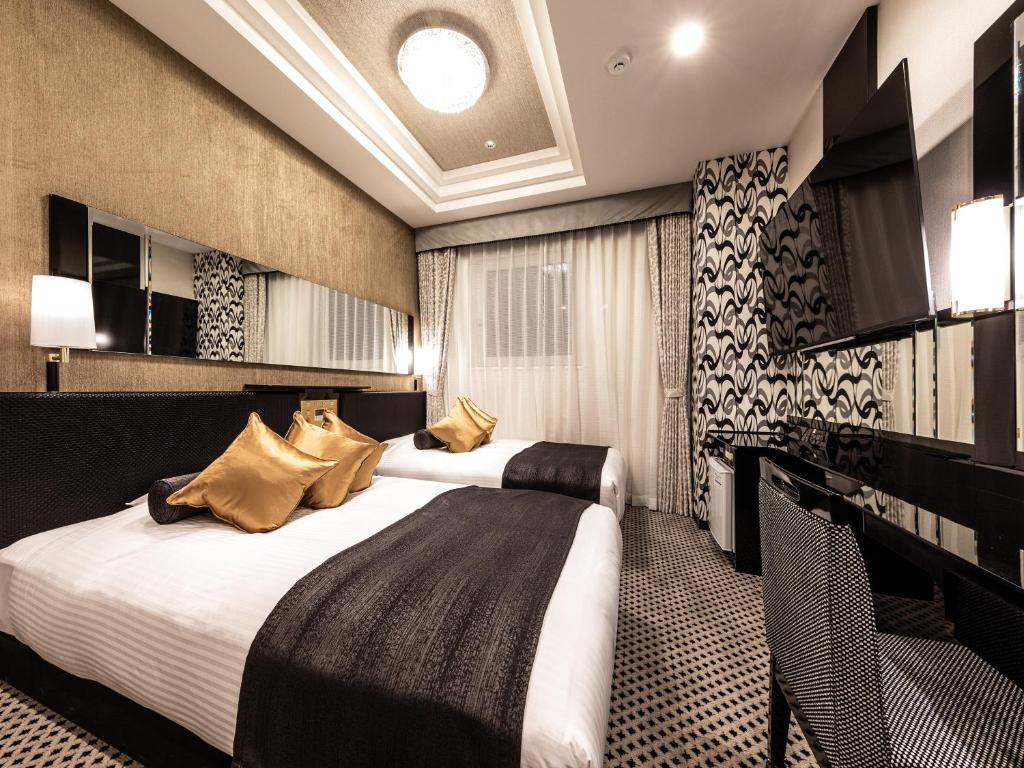 a hotel room with two beds and a television at APA Hotel Kintetsu Nara Ekimae in Nara
