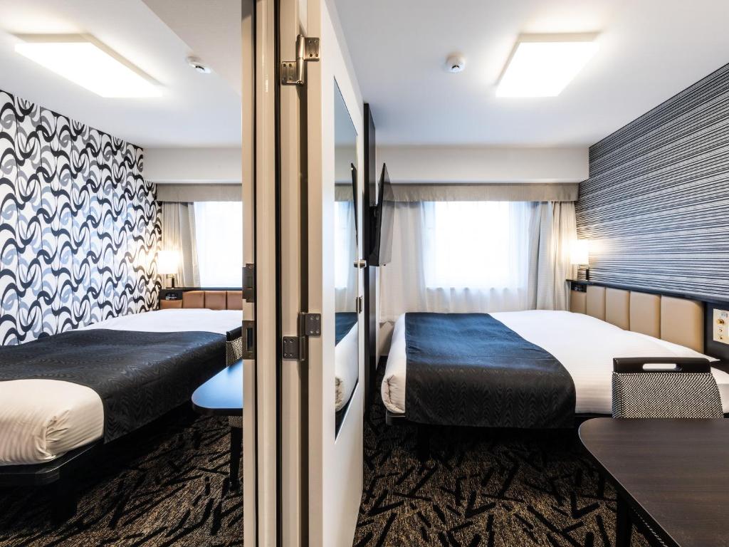 a hotel room with two beds and a desk at APA Hotel Kintetsu Nara Ekimae in Nara