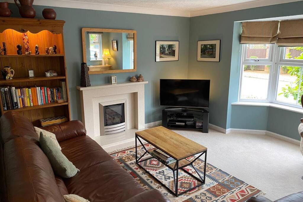 a living room with a couch and a television at Stylish and modern home in Uppingham, Rutland in Uppingham