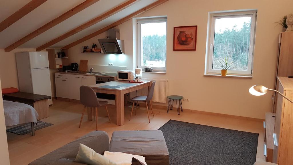 een woonkamer met een tafel en een keuken bij Apartment Business in Wackersdorf