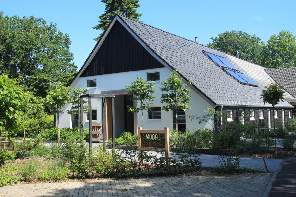 a white house with a black roof at Lagom bed and breakfast in Wilsum