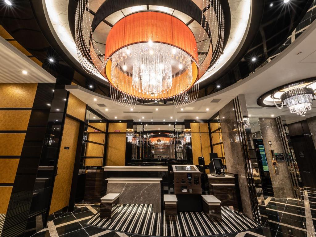 a lobby with a chandelier and benches in a building at APA Hotel Kintetsu Nara Ekimae in Nara