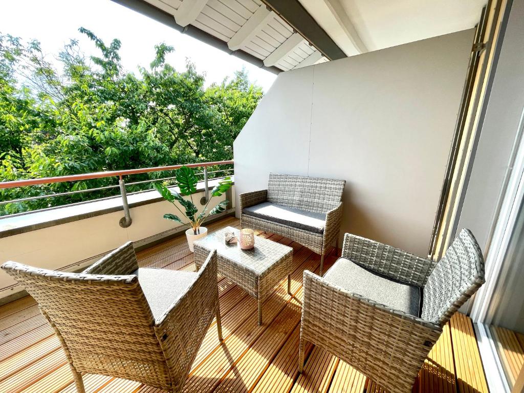 a balcony with wicker chairs and a table at Dresden Rooftop Apartment mit 2 Balkone, Stellplatz, Top Anbindung in Dresden