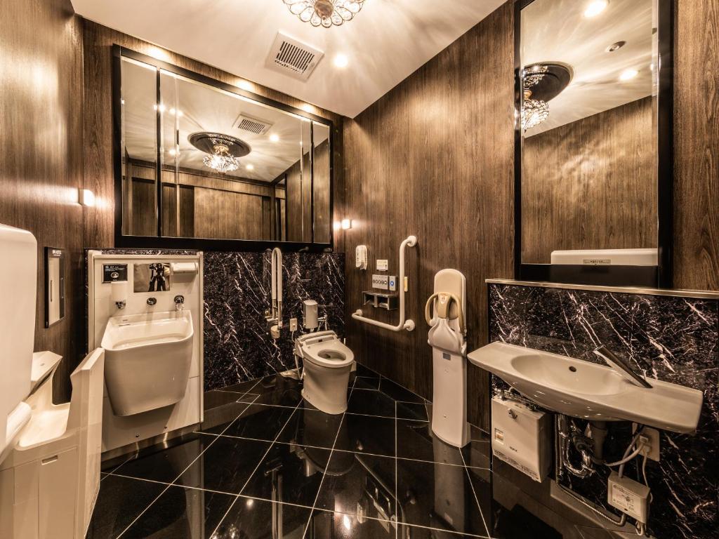 a bathroom with a toilet and a sink and a urinal at APA Hotel Kintetsu Nara Ekimae in Nara