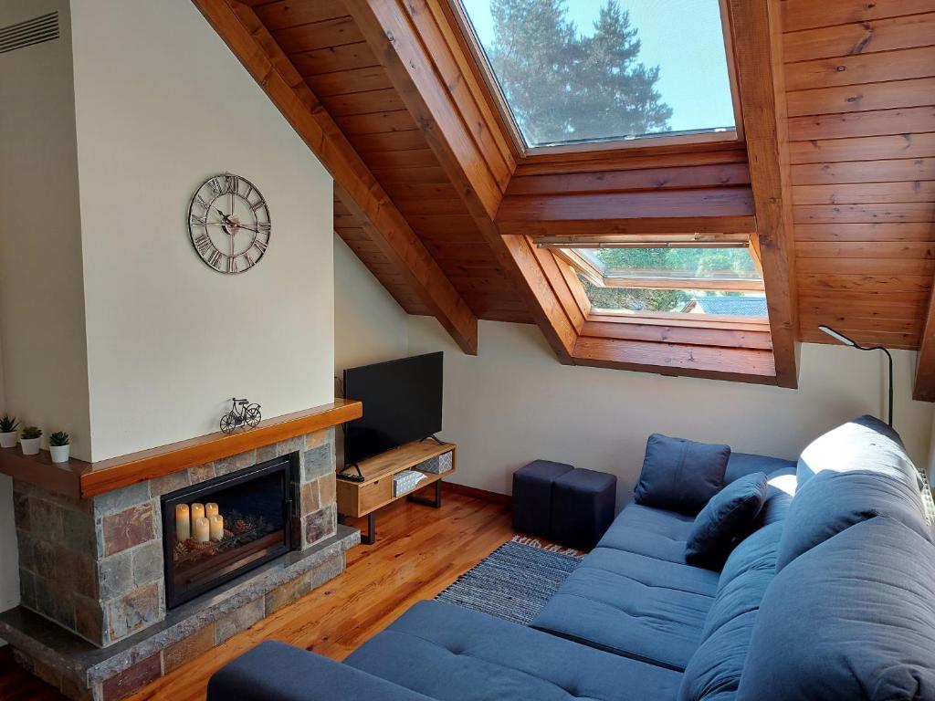 a living room with a blue couch and a fireplace at Family Attic Esterri in Esterri d'Àneu