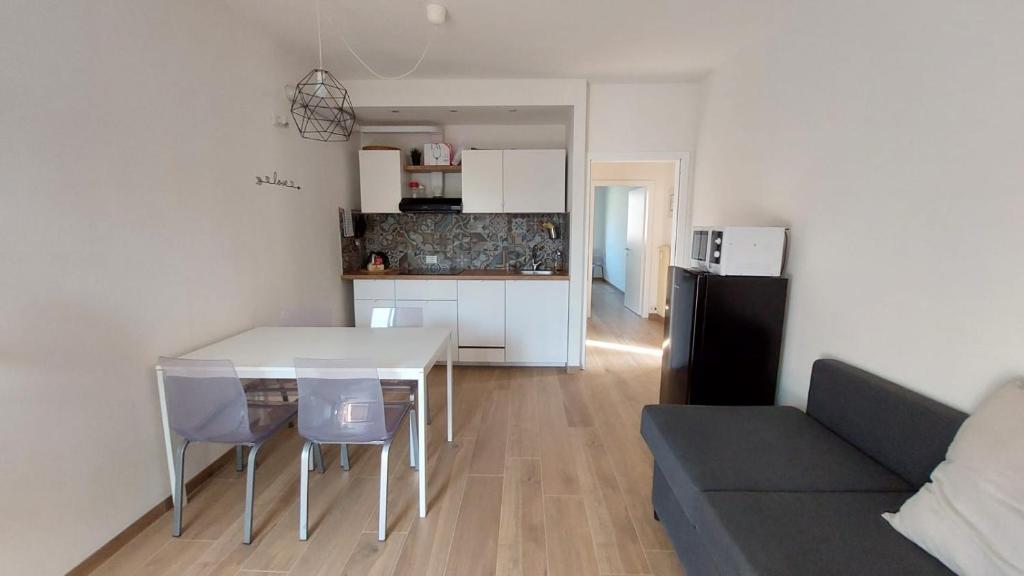 eine Küche und ein Wohnzimmer mit einem Tisch und einem Sofa in der Unterkunft Arco Home in Arco