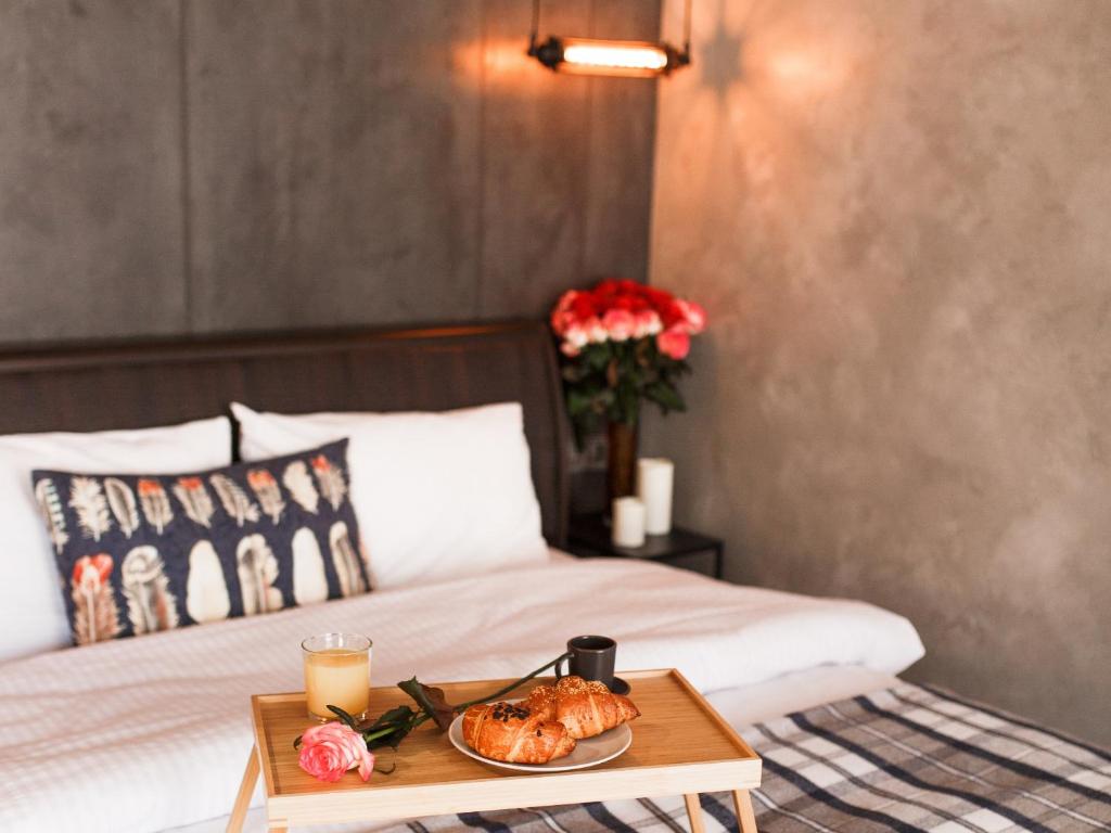 a bed with a tray of food on a table at Style Стильні апартаменти в ЖК "Варшавський" біля парку in Ternopilʼ