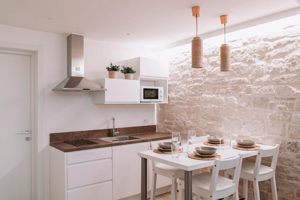 a kitchen with white cabinets and a white table and chairs at INDE Á LA TERRE, GUEST HOUSE Locazione Turistica in Molfetta