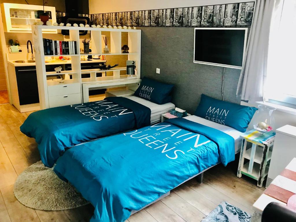 two beds in a room with blue sheets at Wohnung mit Charme, Netflix in Rheinstetten