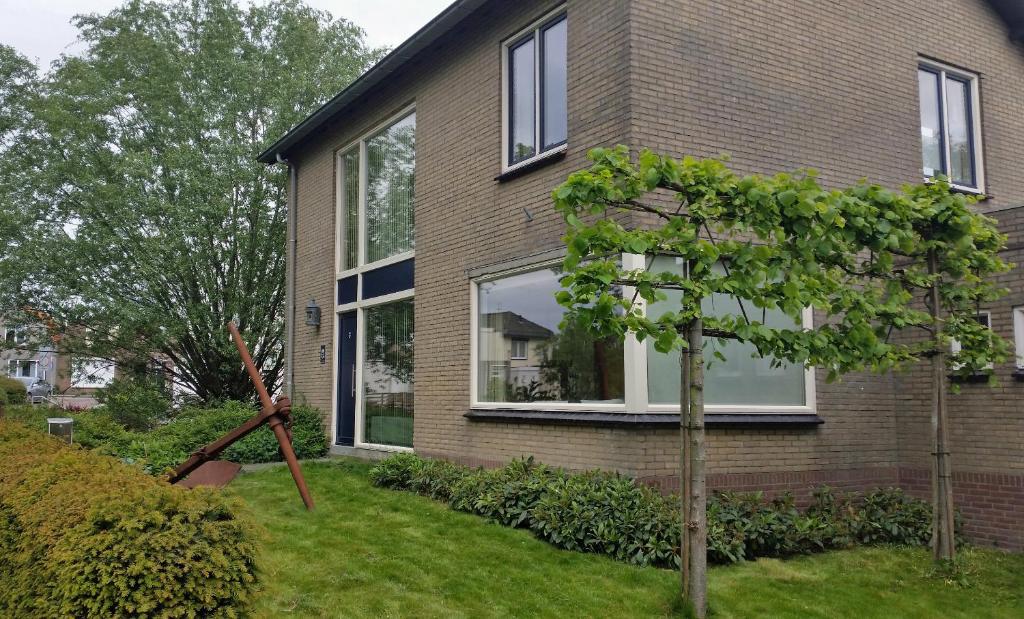 a house with a tree in front of it at Kapiteinshuis Breskens in Breskens