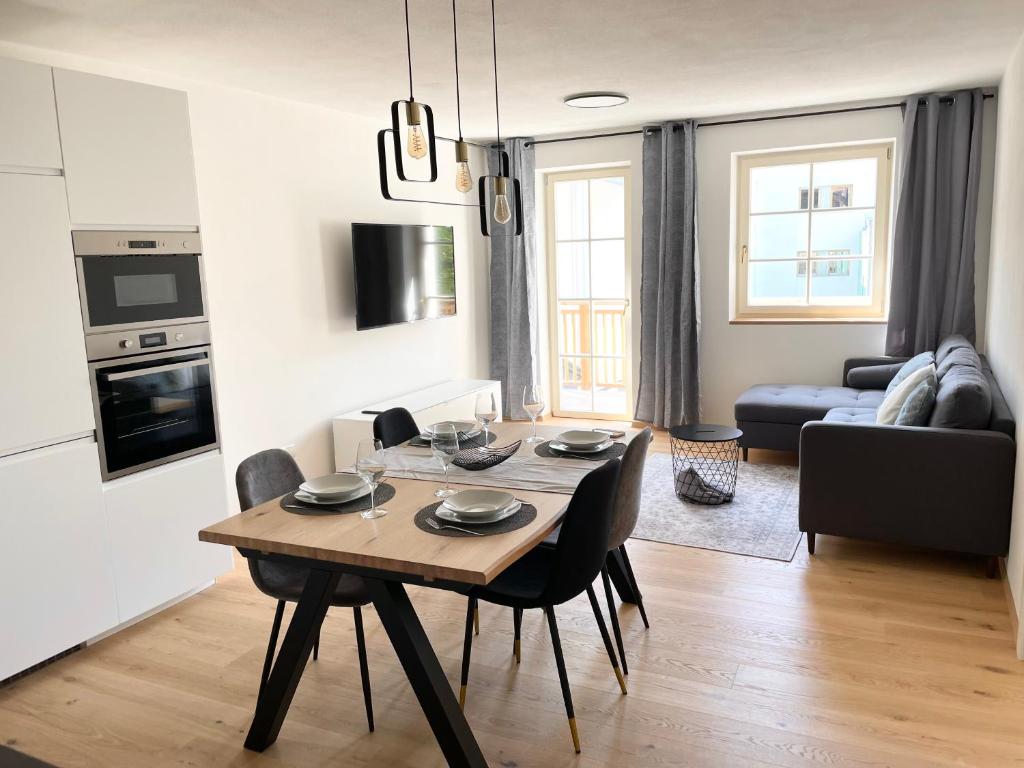 eine Küche und ein Wohnzimmer mit einem Tisch und Stühlen in der Unterkunft Rosa's Boutique Apartment & parking in Meran