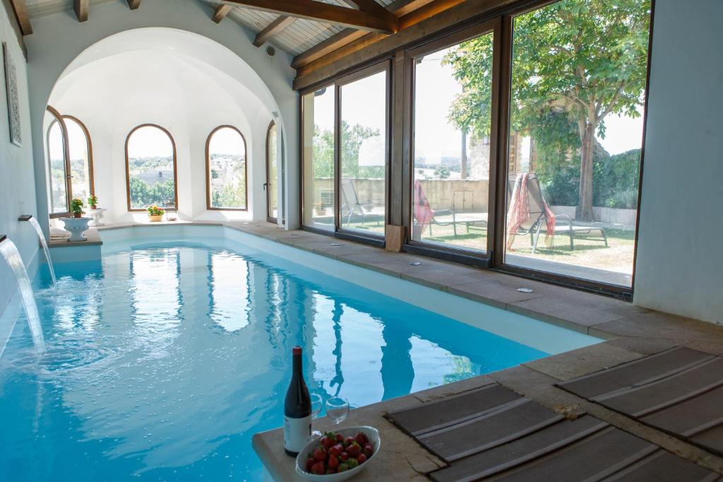 uma piscina com uma garrafa de vinho e uma taça de fruta numa mesa em El Bulín de Cubillo - Casa del Arcipreste em Cubillo