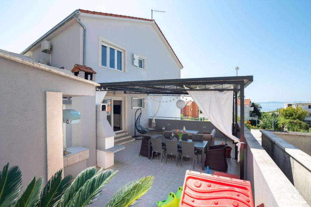 a patio with a table on the roof of a house at Seaside vila Perla in Podstrana