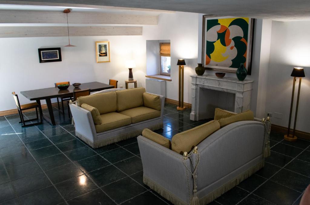 - un salon avec des canapés, une table et une cheminée dans l'établissement RESIDENZA BALIOS, à Vaglio di Basilicata