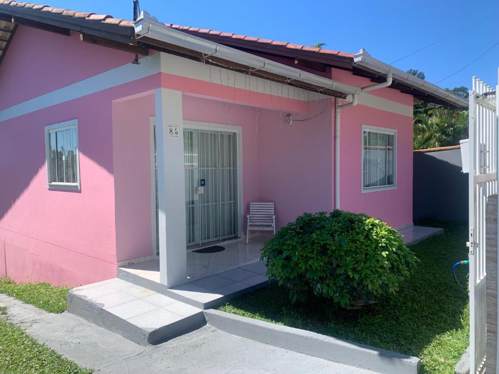 una casa rosa con una silla delante en Casa da bela vista, en Penha