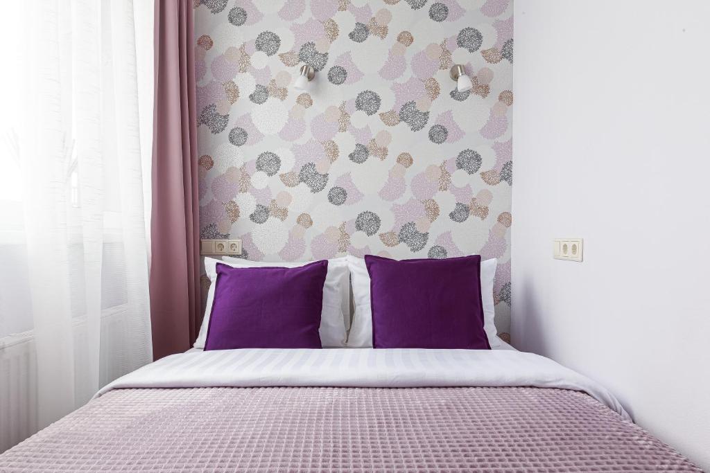 モスクワにあるУютные апартаментыのベッドルーム(紫色の枕が付くベッド付)